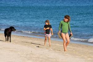 The girls start their day pitching tennis balls into the ocean for Osa.